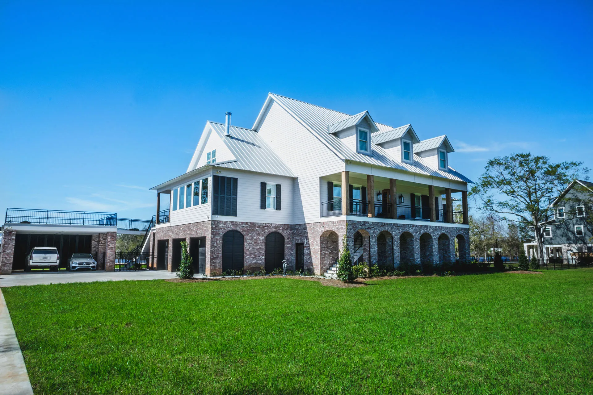 Completed custom home with white siding and wraparound porch