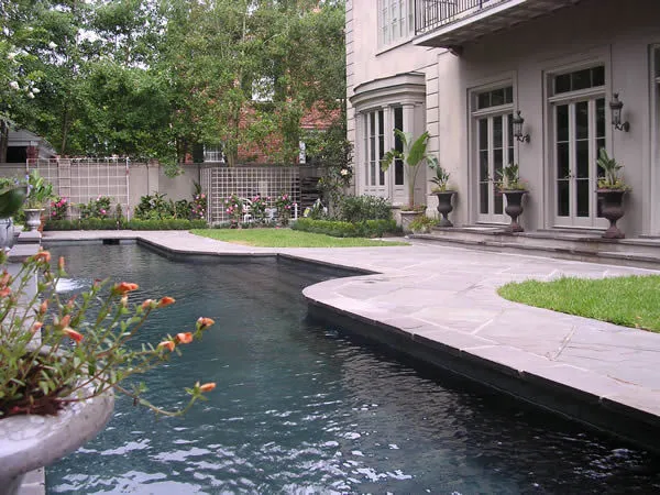Custom pool and patio beside a custom-built home